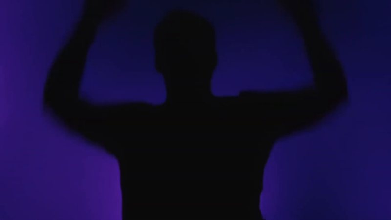 Ultra Priming: silhouette with arms raised against purple light
